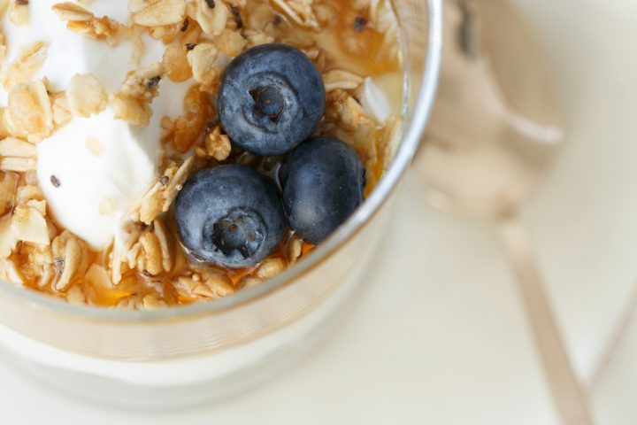 Blueberries on a healthy breakfast in a clear glass bowl