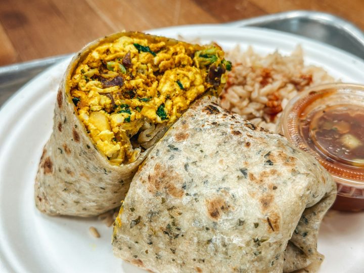 A burrito served on a white plate, the kind you can wrap and freeze for breakfast meal prep