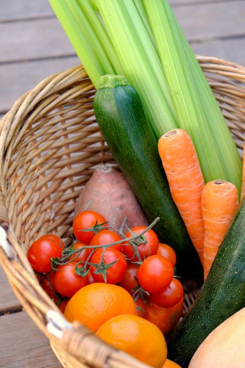 Carrots and cucumber in a brown woven basket