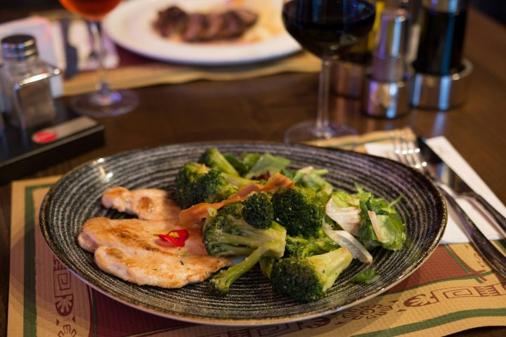 Plate of chicken and broccoli on a table