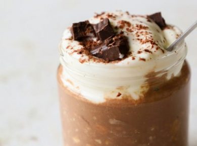 Healthy chocolate oat breakfast topped with whipped cream and chocolate chunks