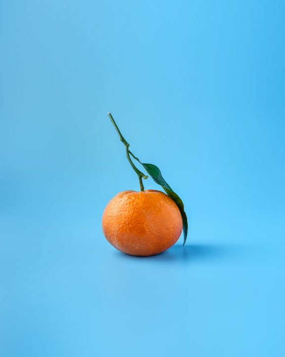 Close-up of orange citrus fruit, the base for clementine jack-o'-lantern Halloween snacks
