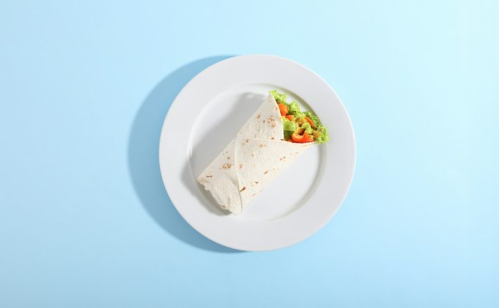 A wrap and salad on a white plate