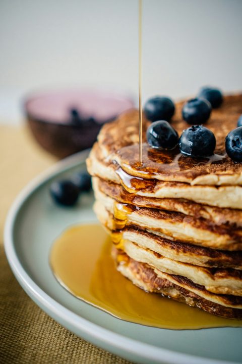 Stack of pancakes with blueberries on a white ceramic plate