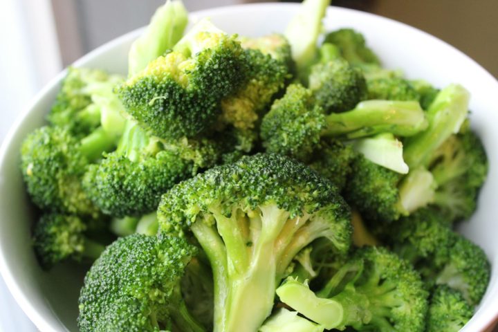 Fresh green broccoli on a white ceramic plate