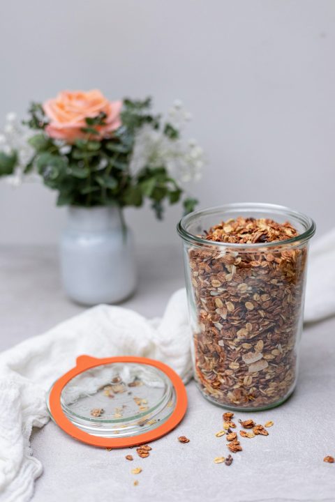 Granola stored in a clear glass jar on a table