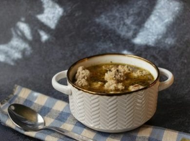 A bowl of soup with a spoon on a table