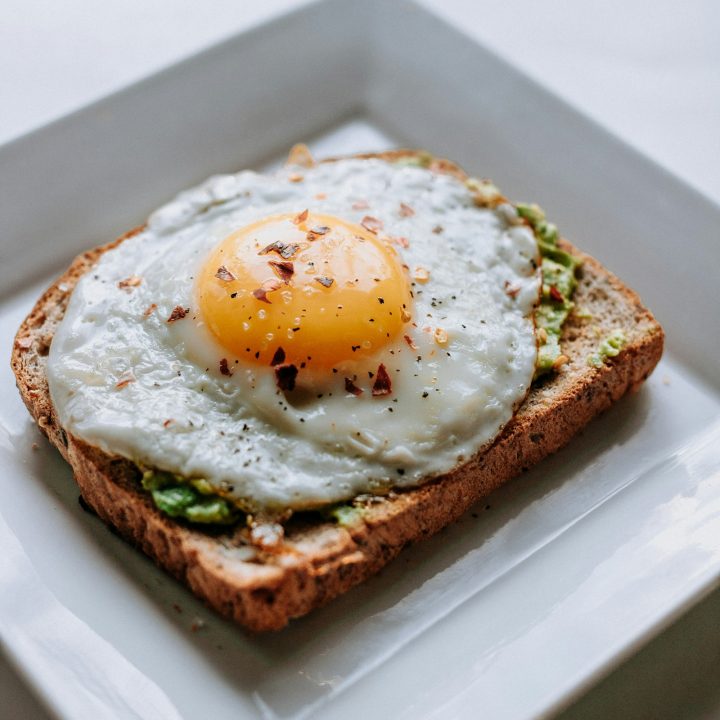 Bread with a sunny side-up egg served on a white ceramic plate