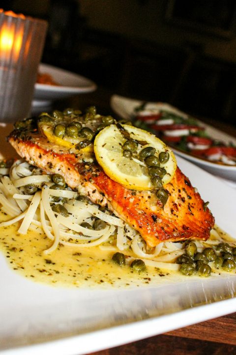 Salmon fillet with lemon and capers over pasta