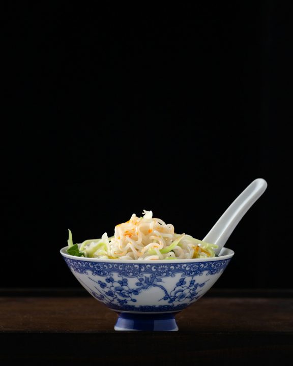 Noodles in a white floral bowl
