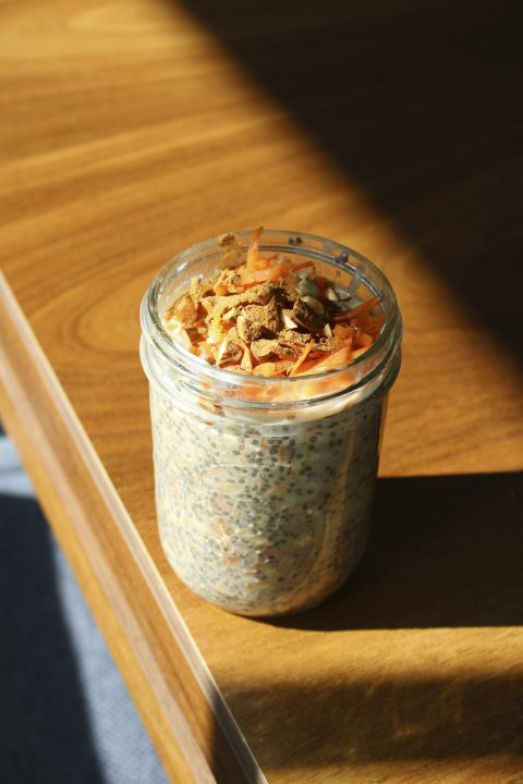 A jar of overnight oats sitting on a wooden table