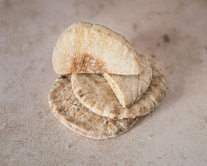 A stack of round pita breads on a stone surface