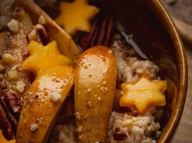 Bowl of porridge topped with roasted spiced pears and persimmons
