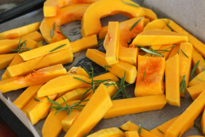 Sliced roasted squash pieces with herbs