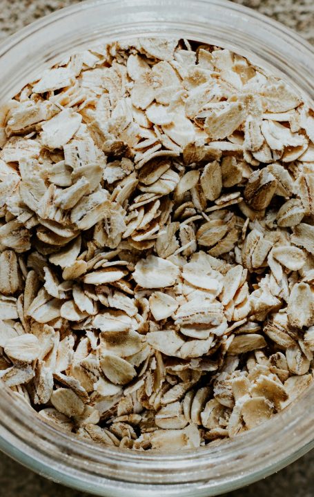 A glass bowl filled with rolled oats on a table