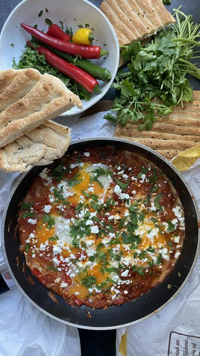Shakshuka served with fresh pide bread and parsley
