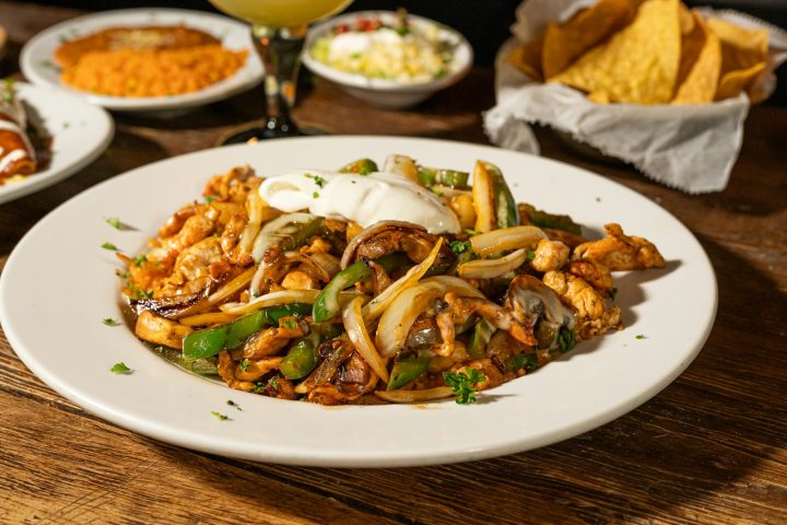 Chicken fajitas with onions, peppers, and sour cream