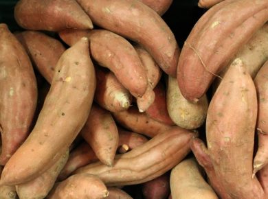 A pile of whole sweet potatoes sitting next to each other